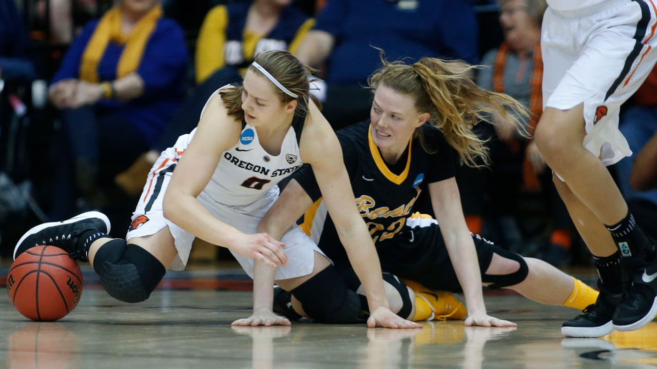 Oregon State's Mikayla Pivec and Long Beach State's Madison Montgomery hit the floor chasing a loose ball during the second half of a first-round game in the women's college basketball tournament Friday in Corvallis, Ore. (AP Photo/ Timothy J. Gonzalez)